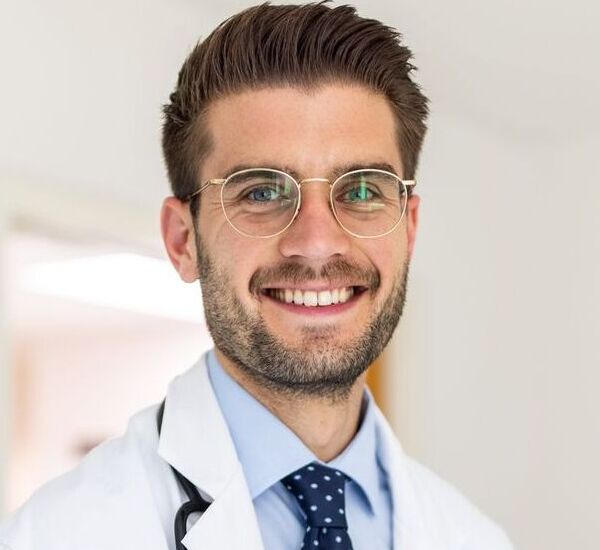 portrait-of-a-happy-young-doctor-in-his-clinic-royalty-free-image-1661432441 (1) (1)